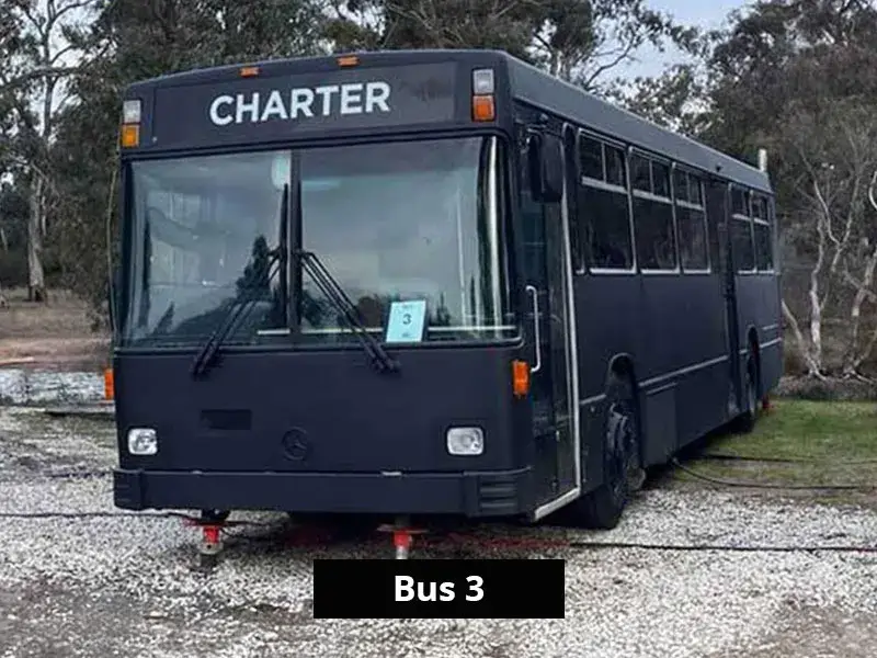 Black-painted charter bus converted into accommodation at Stawell C&C Park near the Grampians.