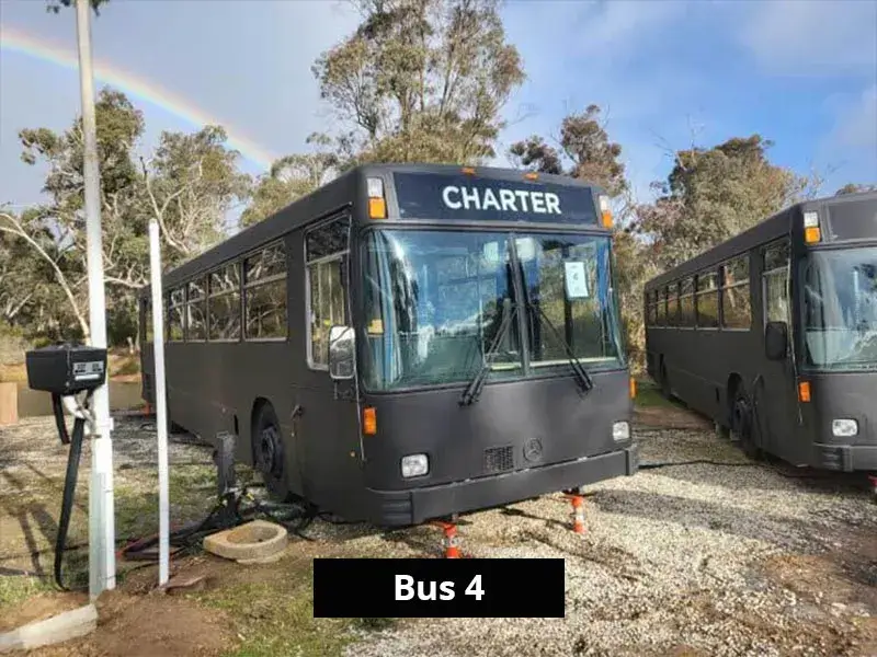 Black retro bus accommodation parked in natural surrounds at Stawell C&C Park.