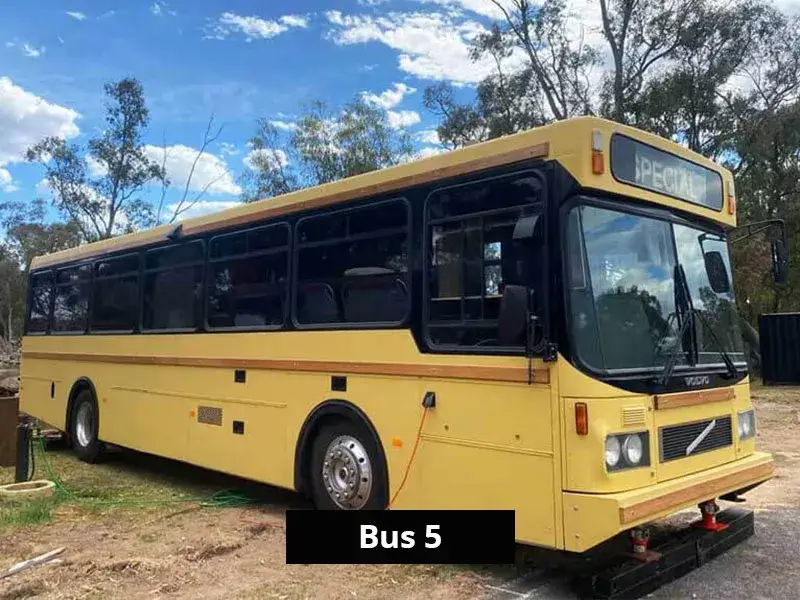 Vintage yellow Volvo bus converted into unique holiday accommodation, parked lakeside at Stawell C&C Park.