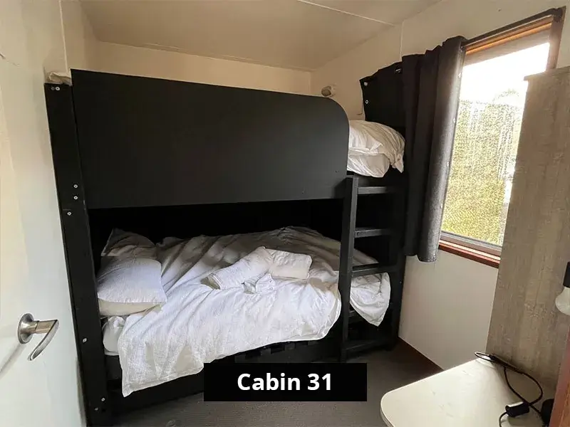 Second bedroom in Cabin 31 with modern black-frame bunk beds, perfect for families or groups visiting the Grampians region.