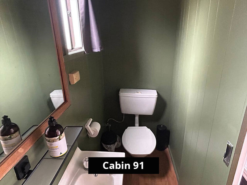 Private ensuite bathroom in Cabin 91 at Stawell C&C Park, featuring a modern vanity, mirror, and toilet.